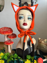 Load image into Gallery viewer, Mannequin head wearing an orange fox fleece headband with decorative mushrooms and plants in the background.