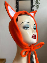 Load image into Gallery viewer, Mannequin head wearing an orange fox fleece headband with decorative mushrooms and plants in the background.