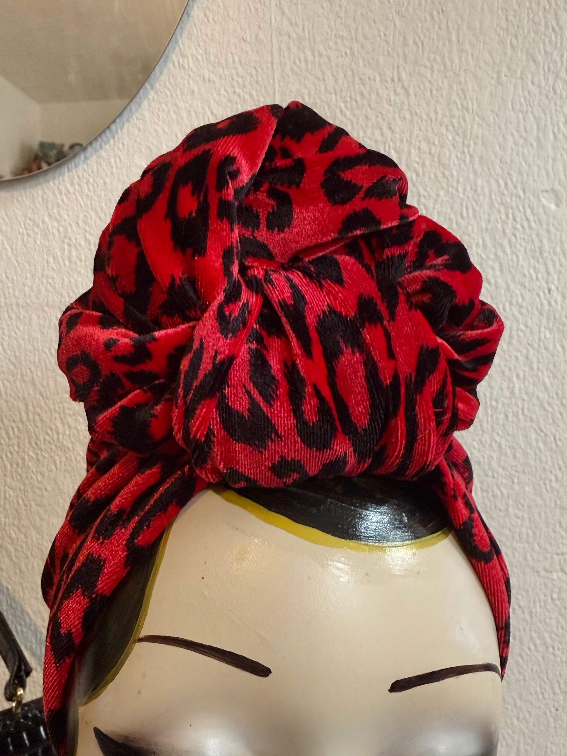 Red leopard print headband on a display head with tattoos 