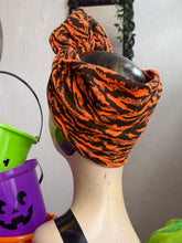 Load image into Gallery viewer, Mannequin head with orange and black zebra print headscarf, Halloween buckets in the background