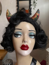 Load image into Gallery viewer, Mannequin head with black wig, red lipstick, and floral devil horns against a neutral background.