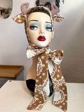 Load image into Gallery viewer, Mannequin head with deer antlers and a patterned scarf, surrounded by decorative mushrooms and leaves.