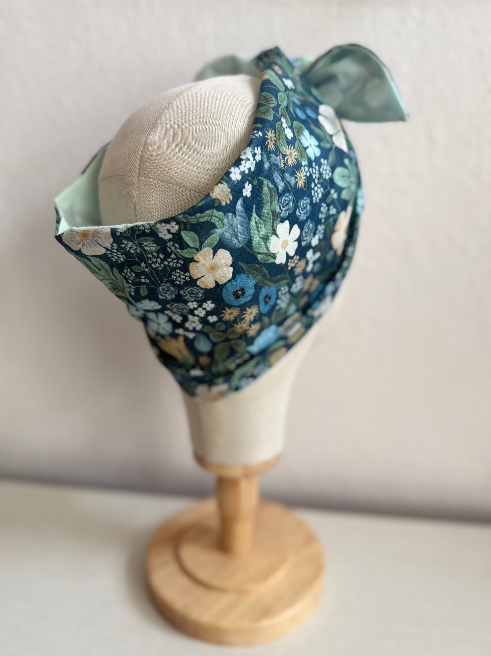 Floral headband on a mannequin head against a plain background