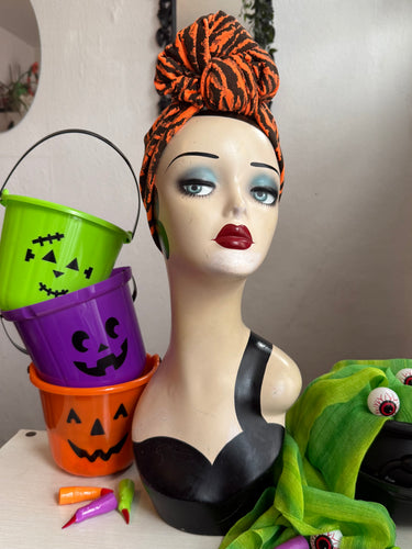 Mannequin head with Halloween-themed decorations including buckets and a green creature.