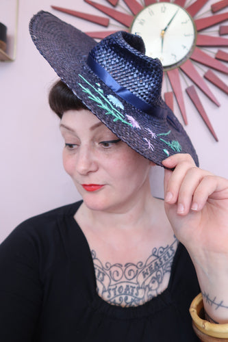 Woman wears a beautiful handmade blue vintage style straw hat  