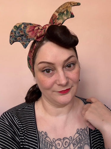 Woman wearing floral bat headband 