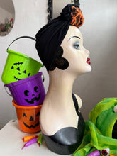 Load image into Gallery viewer, Mannequin head with Halloween-themed decorations including buckets and a green leafy item.