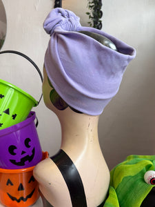 purple headband on a mannequin surrounded by Halloween-themed buckets.