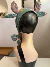 Load image into Gallery viewer, Mannequin head with floral deer antlers surrounded by decorative mushrooms and leaves.