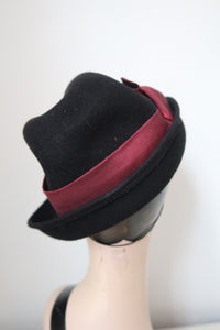Back view of vintage style black felt tilt hat with burgundy trim