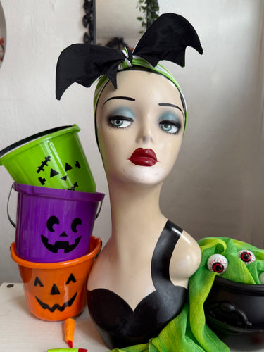 Mannequin head with Halloween-themed bat headscarf