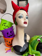 Load image into Gallery viewer, Mannequin head with Halloween-themed accessories including a red headband, colorful buckets, and green scarf.