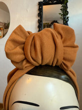Load image into Gallery viewer, mustard headscarf tied in a large bow on a mannequin head against a neutral background.