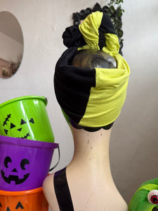 Mannequin head with green and black headband, Halloween buckets in the background