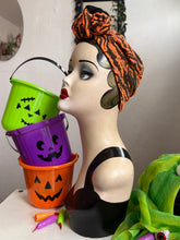 Load image into Gallery viewer, Mannequin head with Halloween-themed decorations including buckets and a turban.