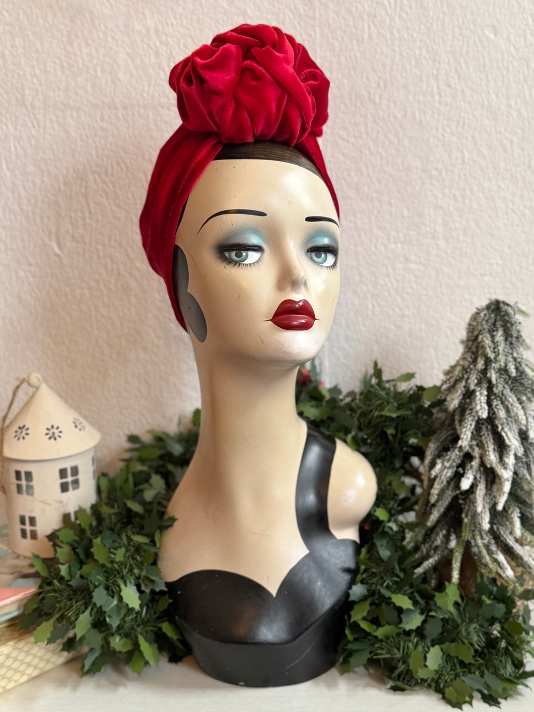 Mannequin head with a red headscarf and decorative background