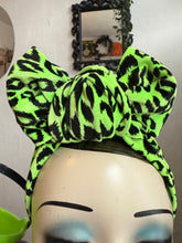 Load image into Gallery viewer, Neon green and black leopard print headband on a mannequin head with a mirror and decorative elements in the background.