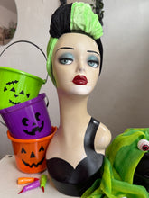 Load image into Gallery viewer, Mannequin head with green hair and makeup, surrounded by Halloween-themed items.
