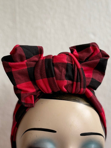 Red and black checkered headband on a mannequin head against a plain background