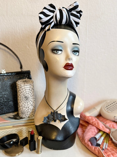 Mannequin head with decorative sleepy hollow striped gothic headband